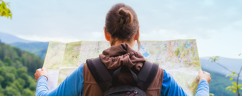 Backpacker looking at the map for directions - SingSaver
